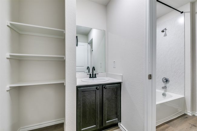 Bathroom featuring vanity, hardwood / wood-style floors, and shower / washtub combination | Image 16