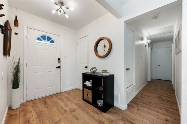 Foyer entrance with baseboards, visible vents, a chandelier, and light wood-style floors | Image 4