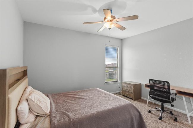 Large secondary bedroom featuring neutral paint, plush carpet, a ceiling fan, and a window with privacy blinds. | Image 16