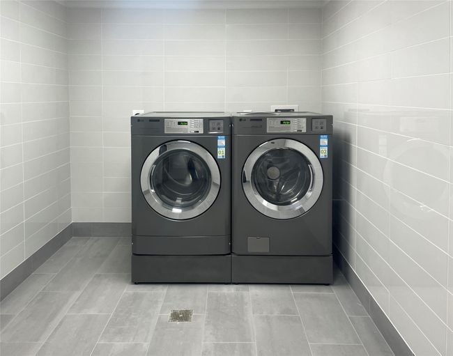 The laundry room in the basement features a commercial grade washer and dryer with built-in app-based payment system. | Image 40