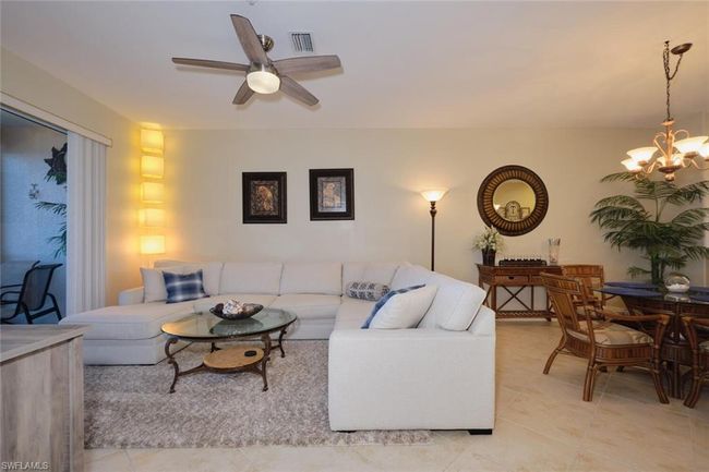 Tiled living room with ceiling fan with notable chandelier | Image 28