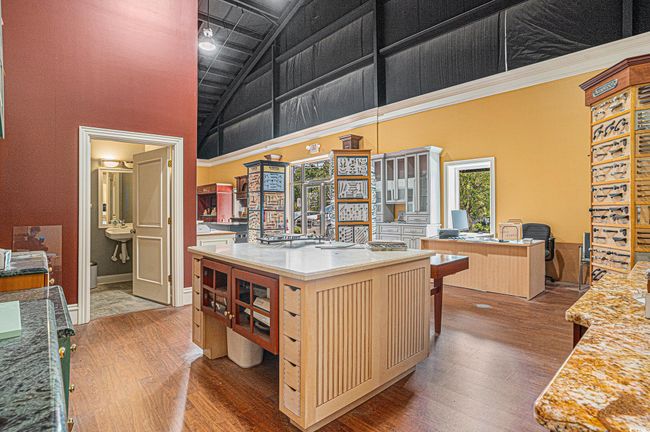 Front room with high vaulted ceiling, wood finished floors, cream cabinets, an office area, and open floor plan | Image 8