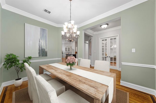 Dining space featuring a chandelier, baseboards, wood finished floors, and crown molding VIRTUALLY STAGED | Image 10