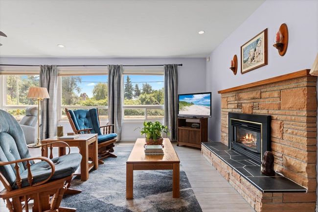 Living room featuring wood finished floors, a fireplace, and recessed lighting | Image 14