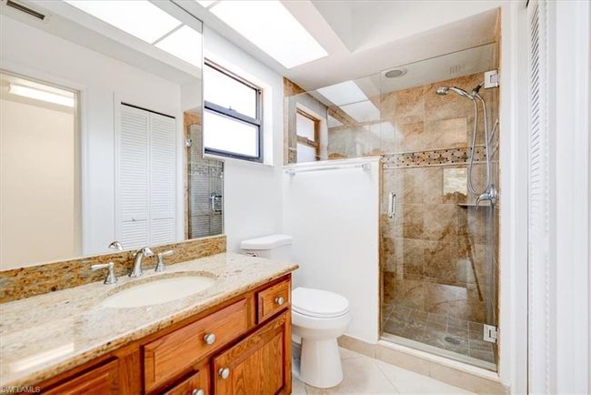 Bathroom with vanity, a closet, toilet, a stall shower, and visible vents | Image 11