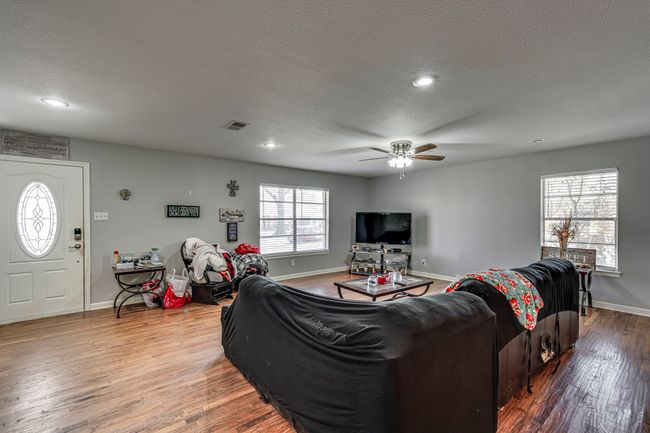 Living area featuring baseboards, ceiling fan, recessed lighting, wood finished floors, and a textured ceiling | Image 11