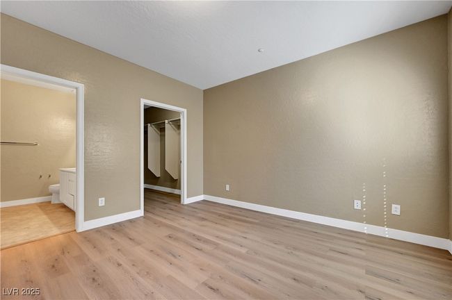 Master bedroom with a walk-in closet, ensuite bathroom, baseboards and luxury vinyl plank flooring | Image 15