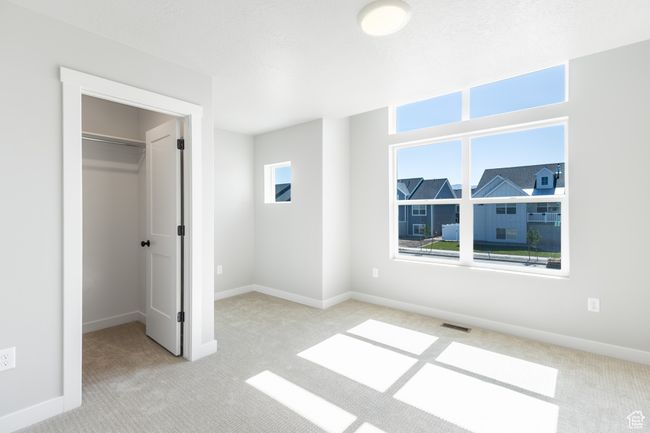 Unfurnished bedroom with carpet, a spacious closet, and a closet | Image 22