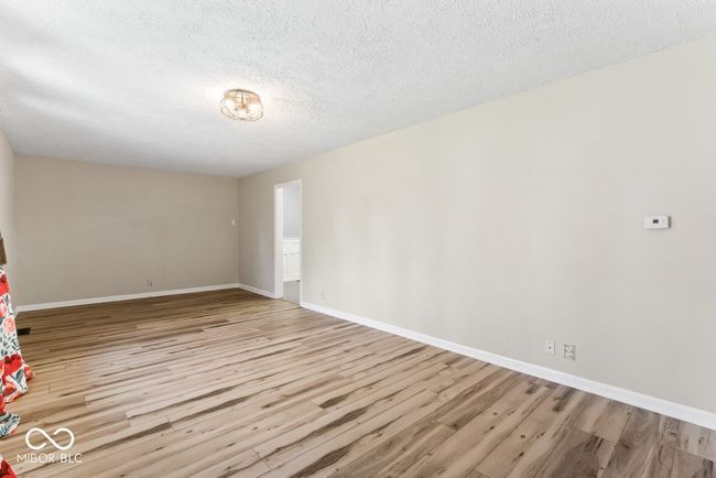 spare room with baseboards, wood finished floors, and a textured ceiling | Image 8