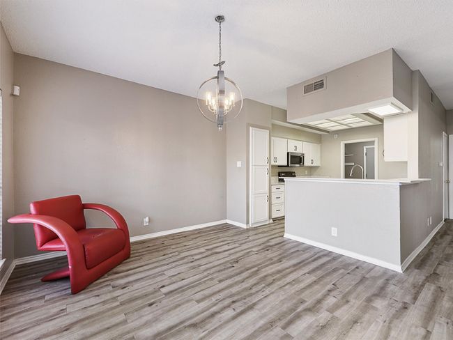 Unfurnished room featuring light wood-type flooring, visible vents, baseboards, and a chandelier | Image 8