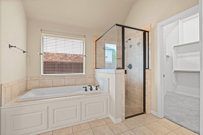 Full bath featuring a bath, a stall shower, tile patterned floors, and a spacious closet | Image 20