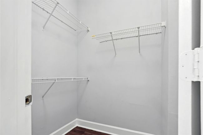 Walk in closet with dark wood-style flooring | Image 16