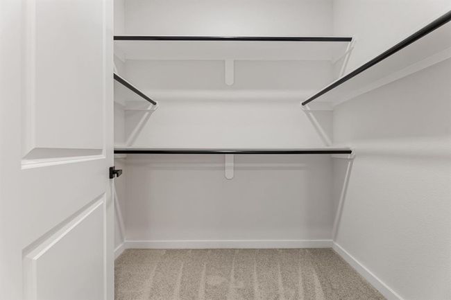 Designed with organization in mind.This spacious walk-in closet offers ample shelving and hanging space to keep your wardrobe neat and accessible. Perfect for those who appreciate both function and style, it’s a dream closet that makes everyday living easier. | Image 24
