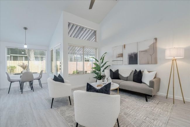 Living area featuring high vaulted ceiling, light wood-style flooring, baseboards, and healthy amount of natural light | Image 13