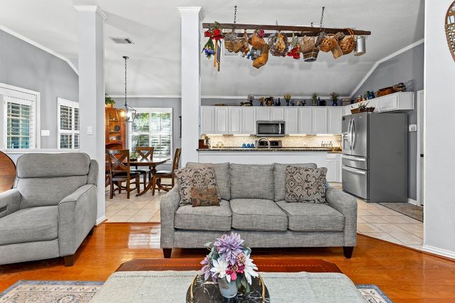 Tiled living room featuring lofted ceiling, ornamental molding, and ornate columns | Image 11