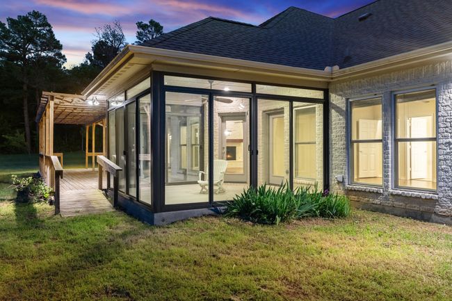 Back of property at dusk with a lawn, a sunroom, and a shingled roof | Image 21