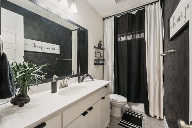 Bathroom featuring vanity, toilet, a shower with shower curtain, tile patterned flooring, and a textured wall | Image 18