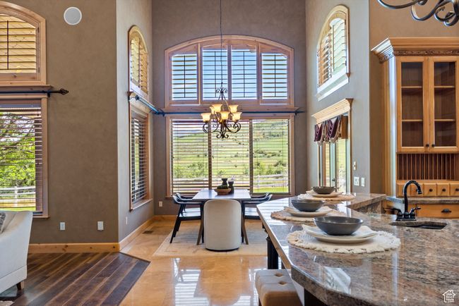 Dining space with a chandelier, healthy amount of natural light, a towering ceiling, and light wood-type flooring | Image 27