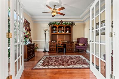 Home office with ceiling fan, french doors, dark hardwood / wood-style flooring, and ornamental molding | Image 3