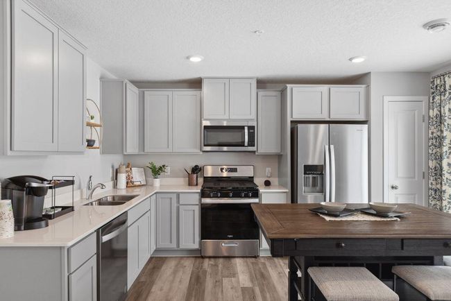 Stainless steel appliances and quartz countertops. Photo is of model home. Colors and options may vary. Ask Sales Agent for details. | Image 4