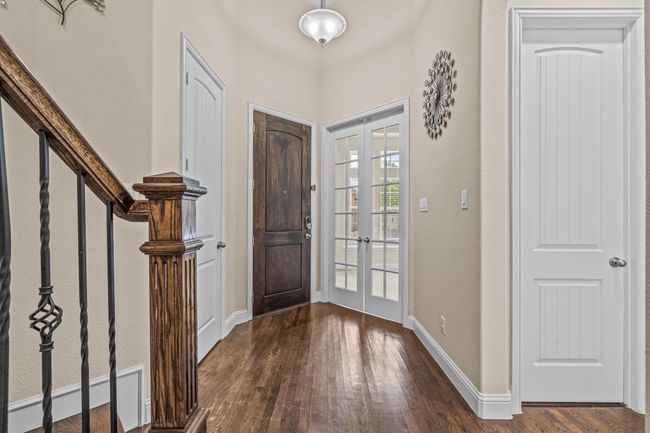 Foyer entrance featuring french doors, dark wood-style floors, baseboards, and stairs | Image 4