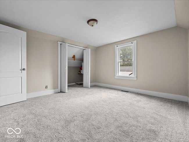 unfurnished bedroom with carpet floors, a closet, and vaulted ceiling | Image 15