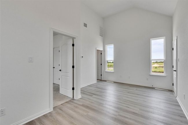 Unfurnished room with light wood-style flooring and high vaulted ceiling | Image 15