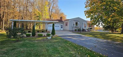 View of front facade with a front yard, attached garage and a carport | Image 2