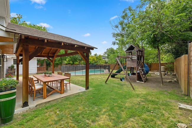 View of play area featuring a patio area, a fenced backyard, a fenced in pool, and a yard | Image 32
