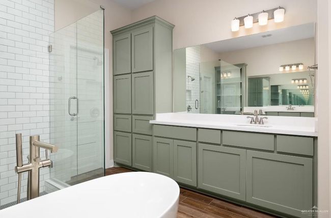 Full bath featuring a freestanding tub, vanity, a stall shower, visible vents, and wood finished floors | Image 22