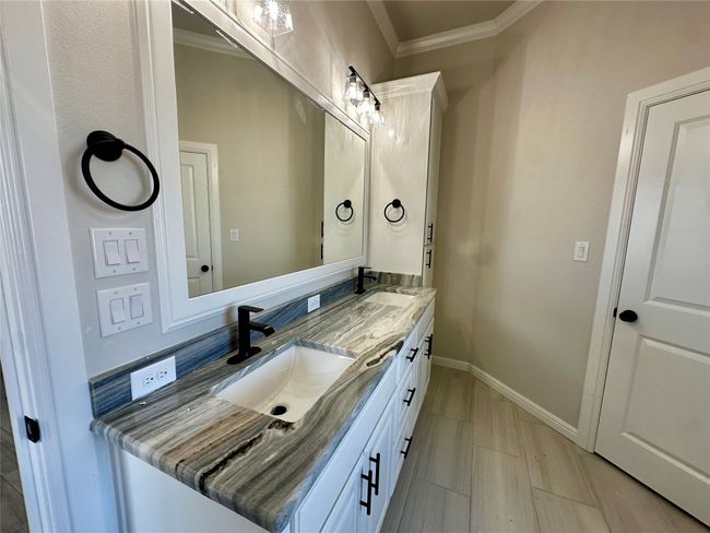 Bathroom with double vanity, ornamental molding, and baseboards | Image 18