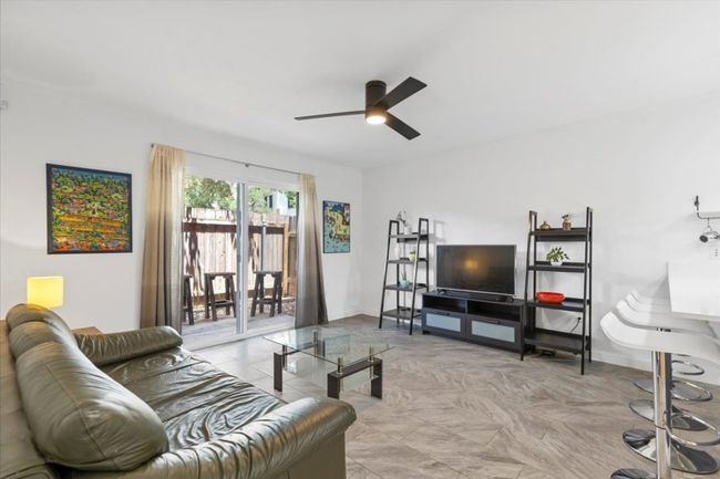 Living room featuring a ceiling fan and baseboards | Image 11