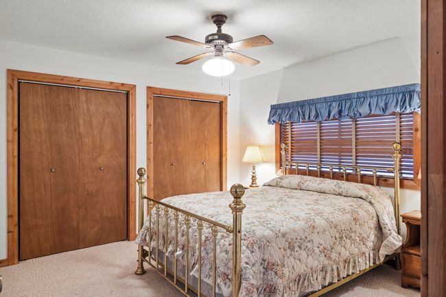 Carpeted bedroom with multiple closets and ceiling fan | Image 31