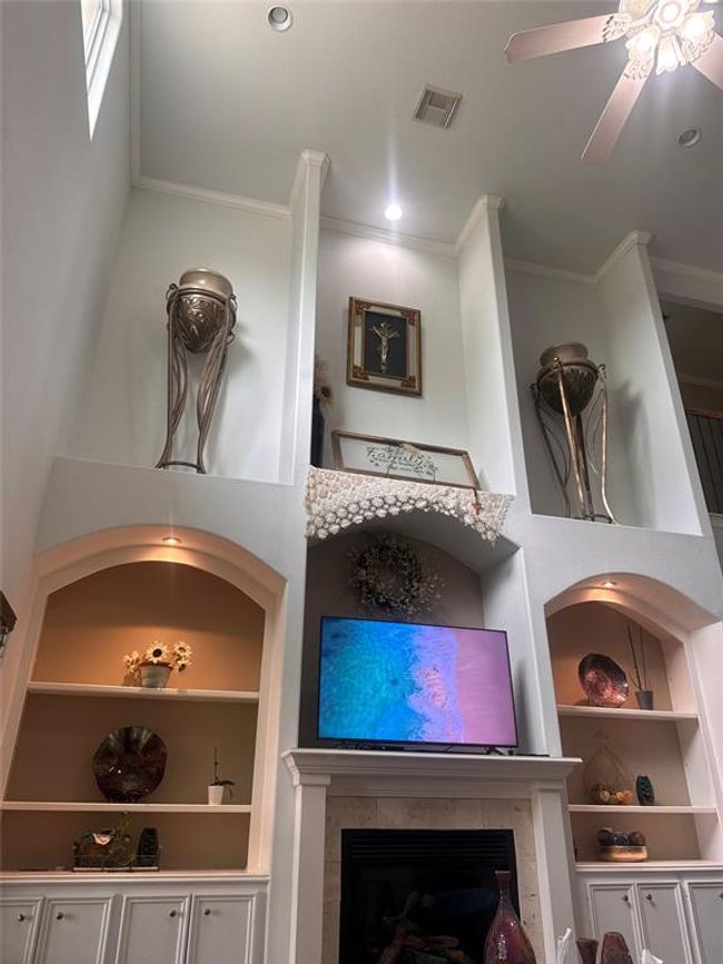 Notice custom art niches on wall in living room. Two vases on top shelves can convey with the property. | Image 9