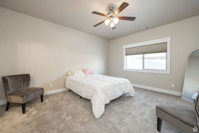 Bedroom featuring light colored carpet and ceiling fan | Image 7