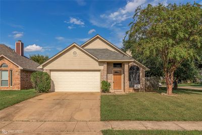 View of front of property featuring a front yard and a garage | Image 1