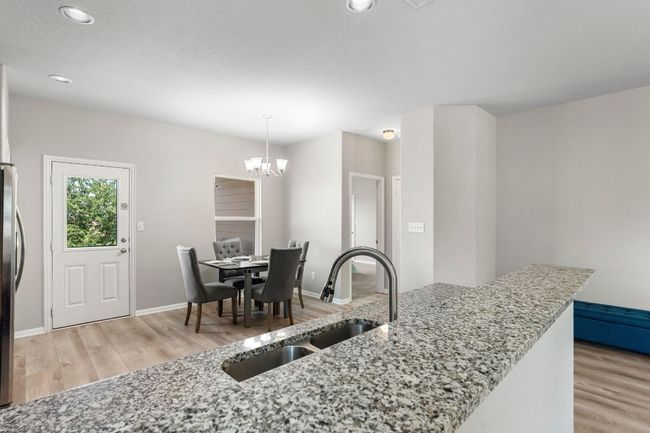 Bar over sink. Kitchen table in distance. Door is to the Primary Bedroom. | Image 5