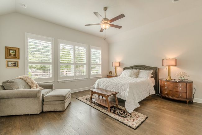 Bedroom featuring vaulted ceiling, multiple windows, wood finished floors, baseboards, and ceiling fan | Image 27