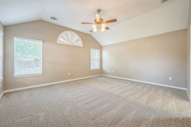 Unfurnished room featuring lofted ceiling, baseboards, visible vents, and ceiling fan | Image 10