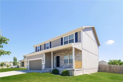 View of front of property featuring a front lawn, covered porch, and a garage | Image 2