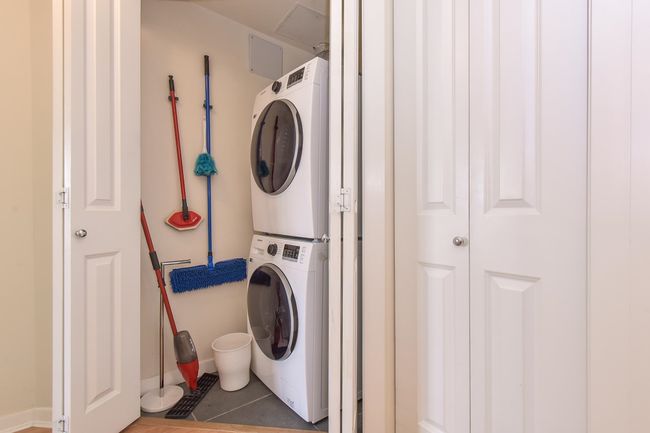 Laundry room featuring stacked washing machine and dryer and tile patterned floors | Image 13