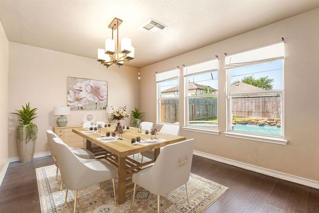 You and your guests will certainly dine in style in this amazing formal dining room! Featuring a gorgeous modern chandelier, large windows, neutral paint, high ceilings, and wood style flooring. Perfect space to entertain family and friends. *Virtually Staged | Image 6