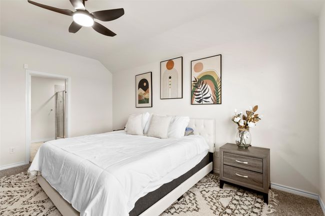 Bedroom featuring a ceiling fan, light carpet, baseboards, ensuite bath, and lofted ceiling | Image 19