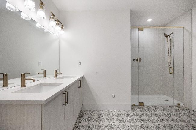 Bathroom with a stall shower, baseboards, double vanity, recessed lighting, and tile patterned floors | Image 24