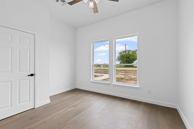 Unfurnished room with ceiling fan, visible vents, baseboards, and wood finished floors | Image 30