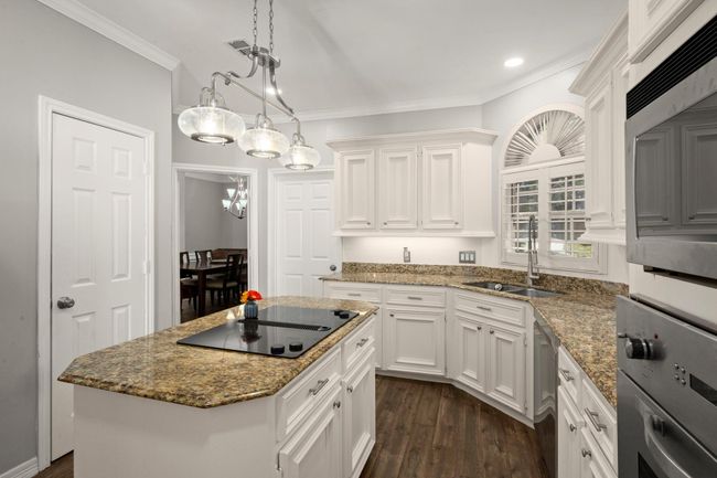 A stylish white kitchen is a classic statement and fits this home perfectly. The sink has a view over the front lawn with a deep sink and beautiful faucet. | Image 16