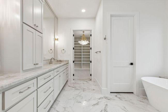 Full bath with vanity, a freestanding tub, light marble finish flooring, a walk in closet, and recessed lighting | Image 16