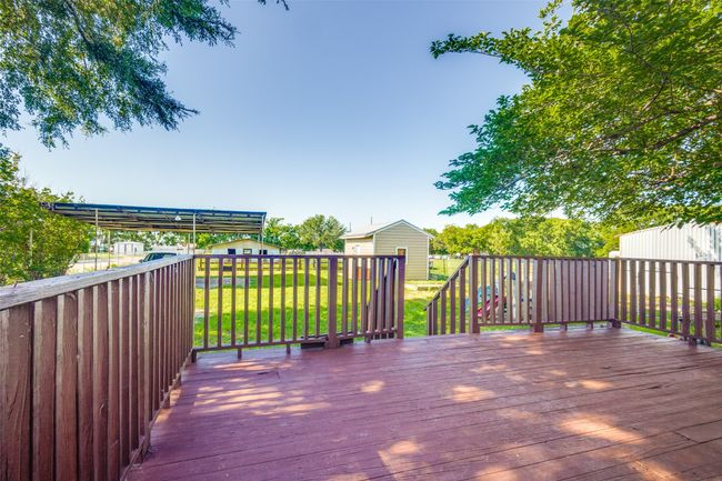 Surrounded by mature trees, this serene property offers exceptional privacy, a small barn and shed for added utility, and a spacious back deck perfect for entertaining. | Image 18