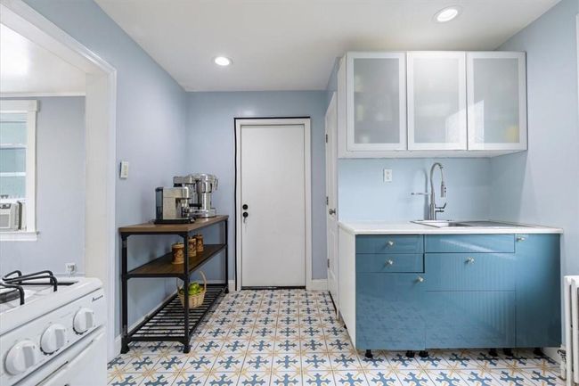 Kitchen featuring range, light tile patterned floors, and white cabinets | Image 7