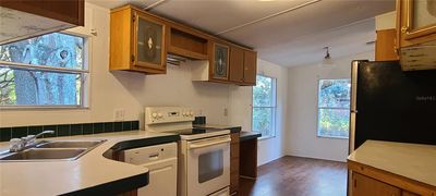 Kitchen with dinette looking out into the spacious landscape. | Image 3